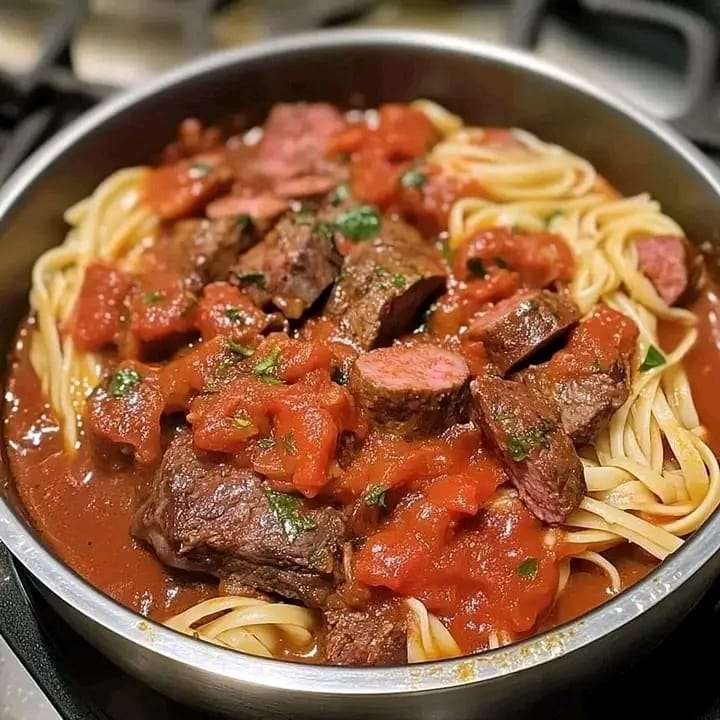 A pot of Italian Sunday Sauce with beef, sausage, and fresh basil, served over spaghetti.