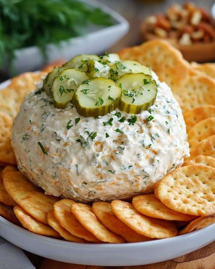 A tangy Dill Pickle Cheese Ball coated with chopped pecans, served with crackers and fresh veggies.