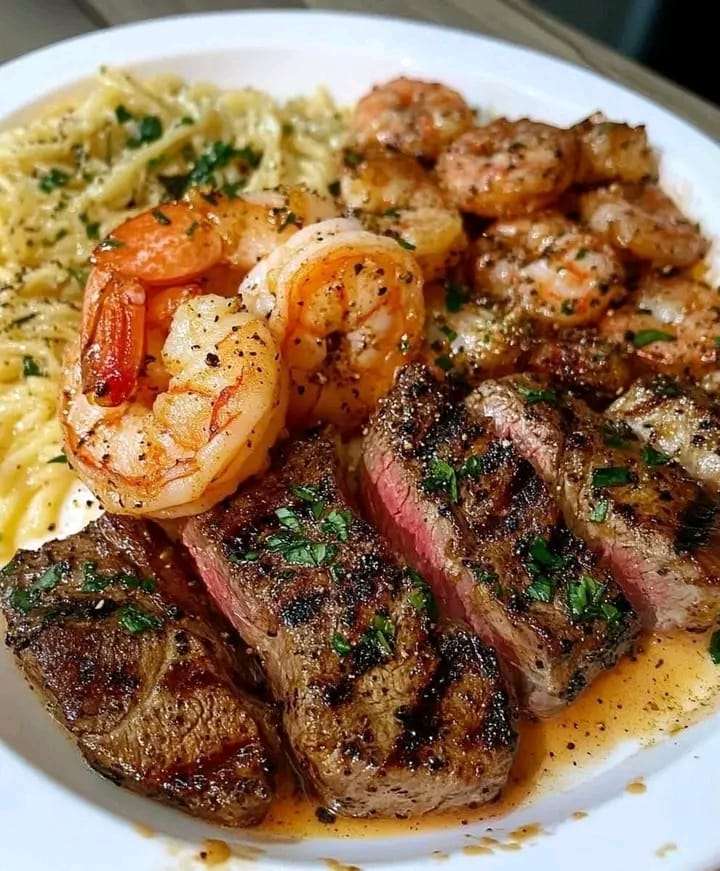 A plate of Cajun shrimp and steak, topped with creamy sauce and garnished with parsley, served with a side of vegetables.