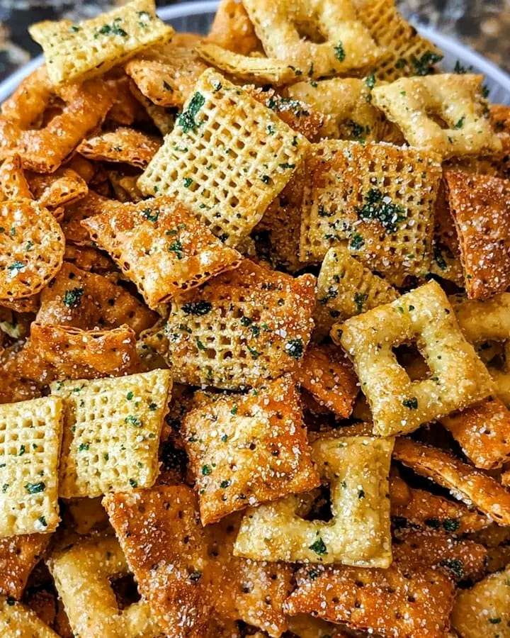 Bowl of Ranch Trail Mix with pretzels, Chex cereal, cheddar crackers, and peanuts.