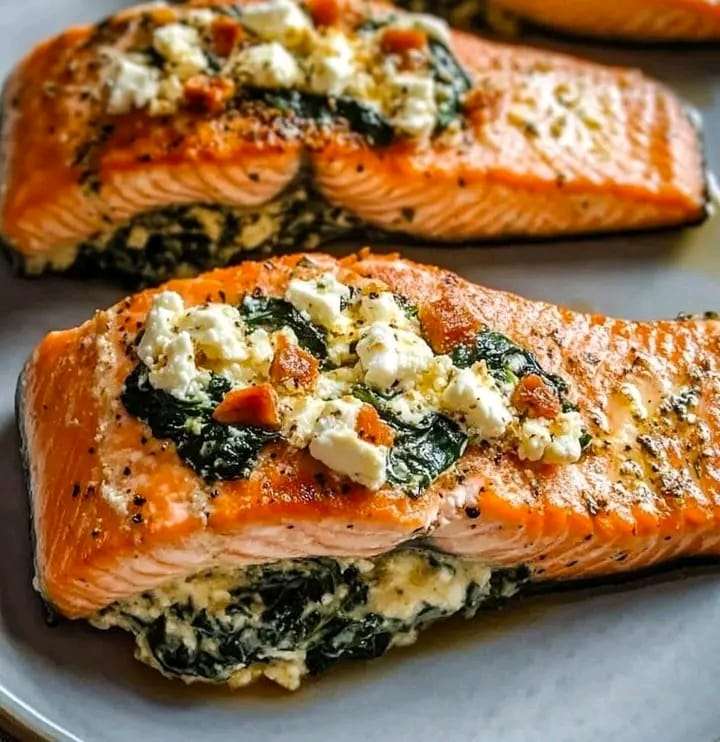 A perfectly baked Stuffed Salmon with Spinach and Feta, garnished with lemon slices and fresh parsley on a serving plate.