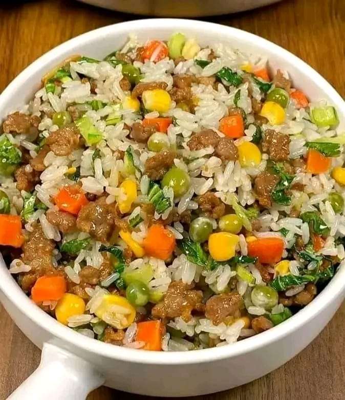 Delicious Fried Rice with Veggies, served hot with green onions and spinach garnish.