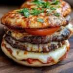 A plate of Mini Pizza Burgers topped with melted mozzarella, pizza sauce, and fresh tomato slices.