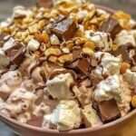 A bowl of creamy Rocky Road Fluff Salad topped with marshmallows, nuts, and chocolate chips.