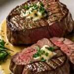 Perfectly cooked filet mignon steaks topped with creamy Parmesan mustard sauce, garnished with parsley.