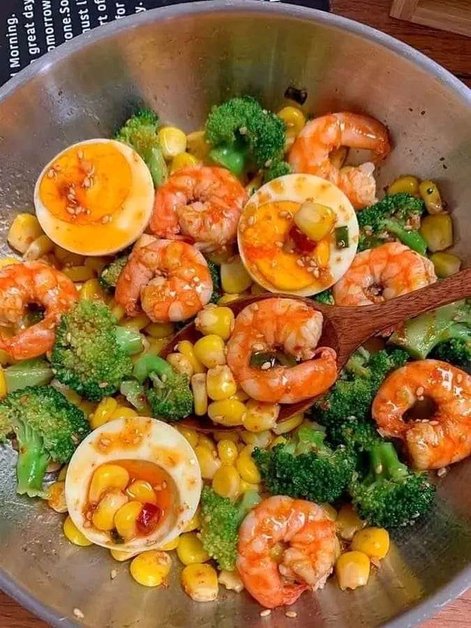 Colorful Shrimp and Broccoli Salad with corn, hard-boiled eggs, and a light mustard dressing, garnished with sesame seeds.