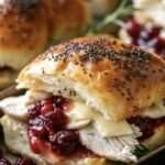 A platter of golden Baked Cranberry Turkey Sliders with gooey Havarti cheese and cranberry sauce.