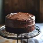 A decadent Classic Chocolate Cake with rich chocolate frosting and a slice ready to serve.