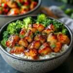 A vibrant Honey Lemon Chicken Broccoli Bowl with golden chicken slices, roasted broccoli, and a drizzle of tangy sauce.