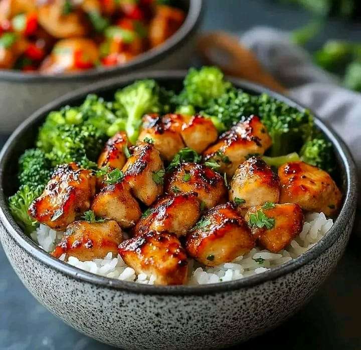 A vibrant Honey Lemon Chicken Broccoli Bowl with golden chicken slices, roasted broccoli, and a drizzle of tangy sauce.