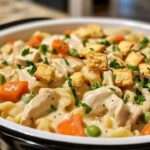 A plate of creamy Chicken Pot Pie Pasta garnished with parsley and crushed crackers.