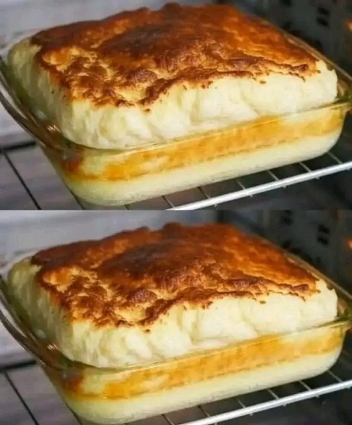 A glass baking dish inside an oven featuring a savory base topped with a massive, golden-brown, and airy soufflé-style egg-white crust.